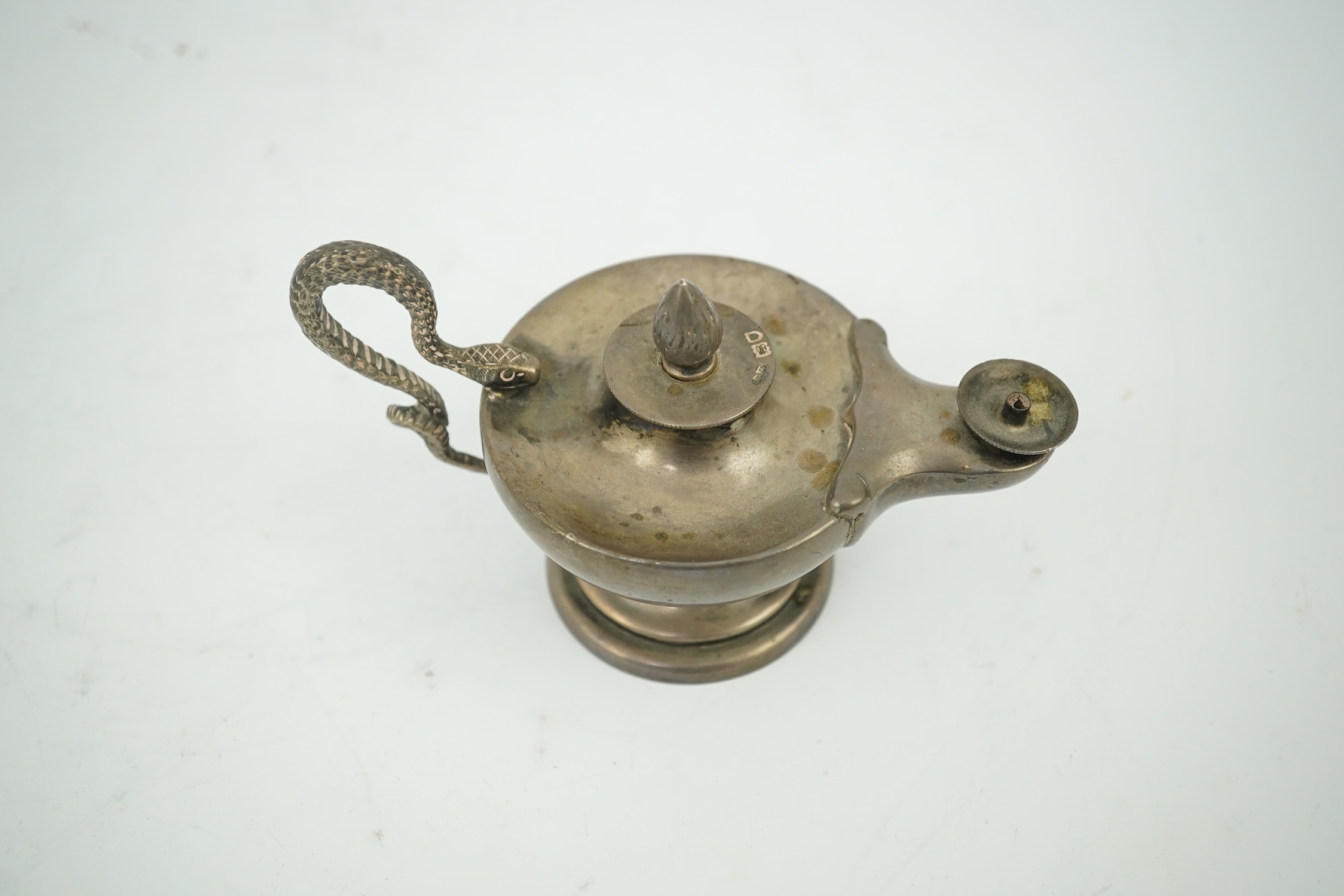 A late Victorian silver club lighter modelled as an oil lamp with serpent handle, Goldsmiths & Silversmiths Co Ltd, London, 1900, length 12cm. Condition - fair to good